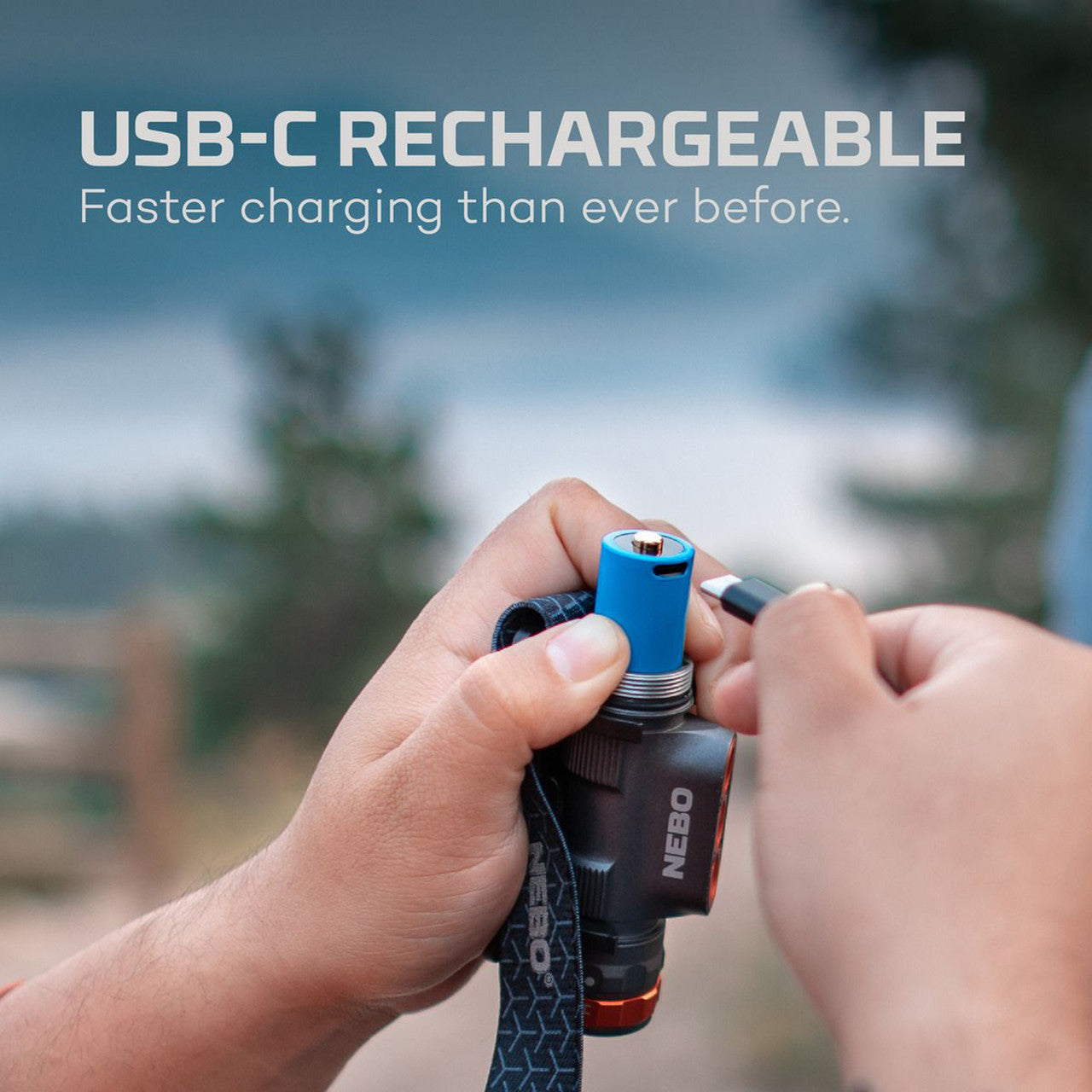 USB-C rechargeable device, likely a flashlight or portable light, being held and charged outdoors.