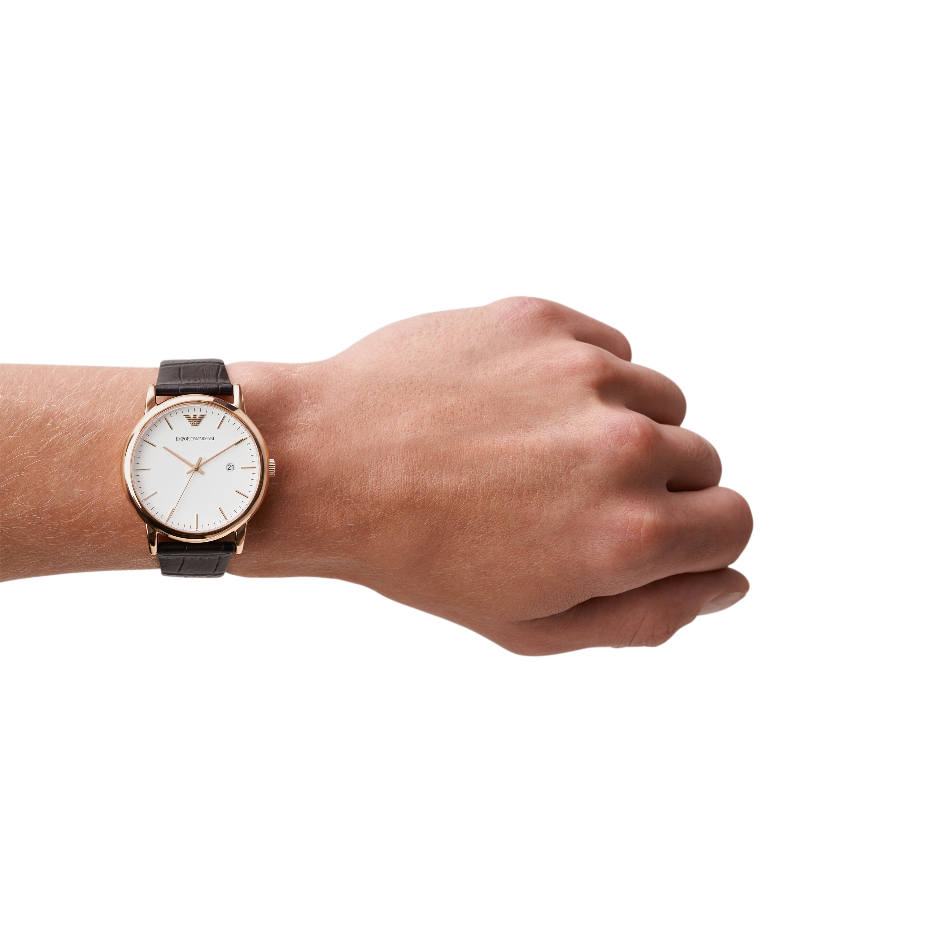 Wristwatch with a brown leather strap and white face worn on a person’s wrist.