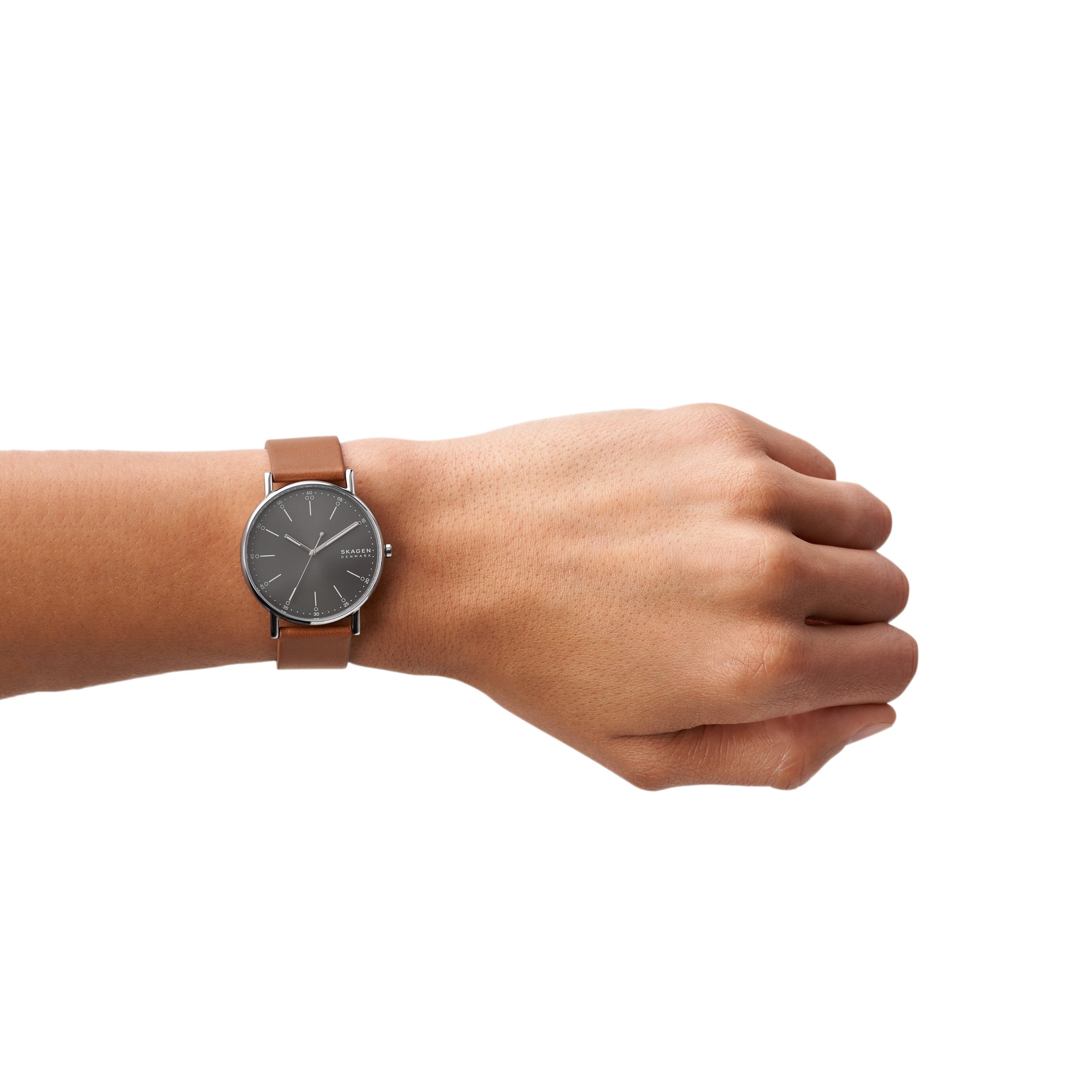 Wristwatch with a brown leather strap and dark circular face worn on a person’s wrist.