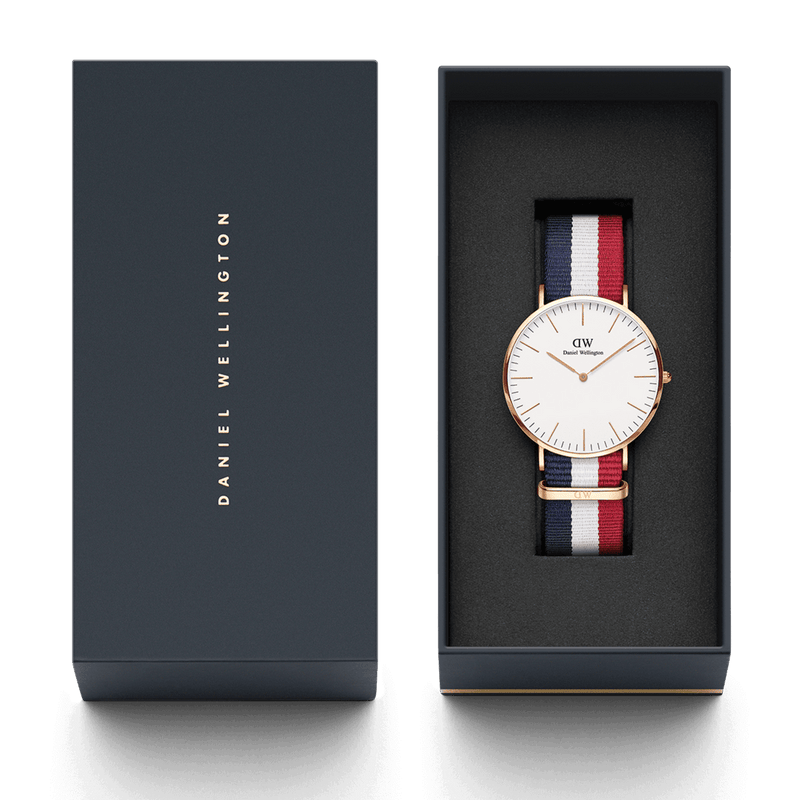 Wristwatch with a white face and striped fabric band in a gift box.