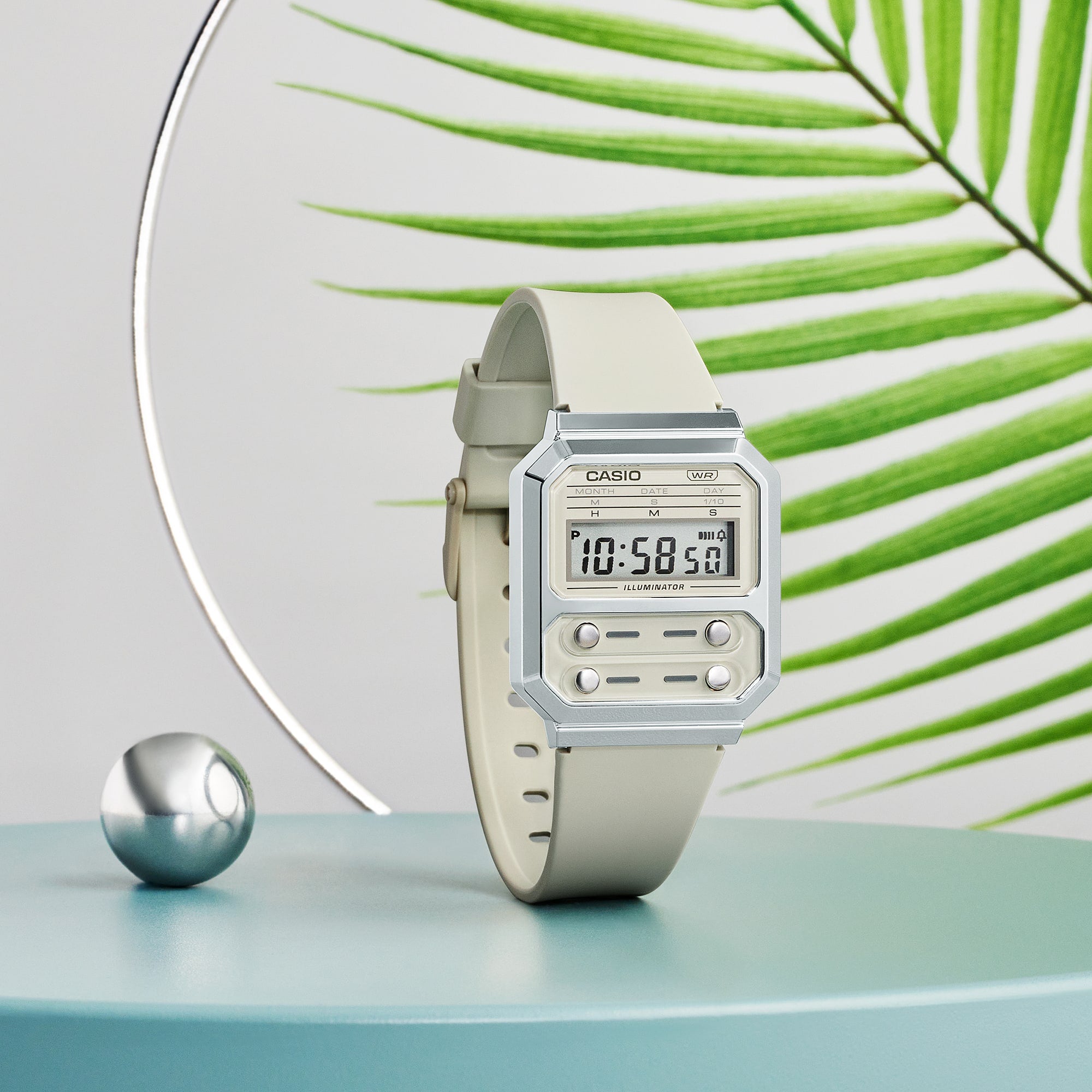 Digital wristwatch with a square face and light-colored band.
