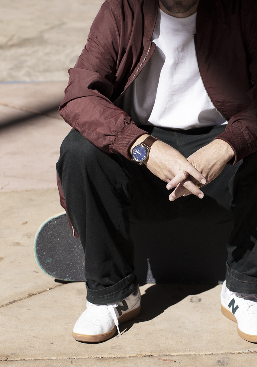 Wristwatch with a blue face worn on a person’s wrist.