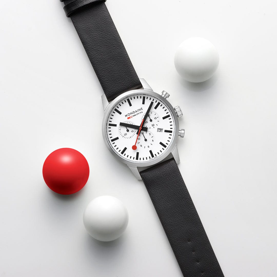 Wristwatch with a white face, black leather strap, and chronograph subdials.