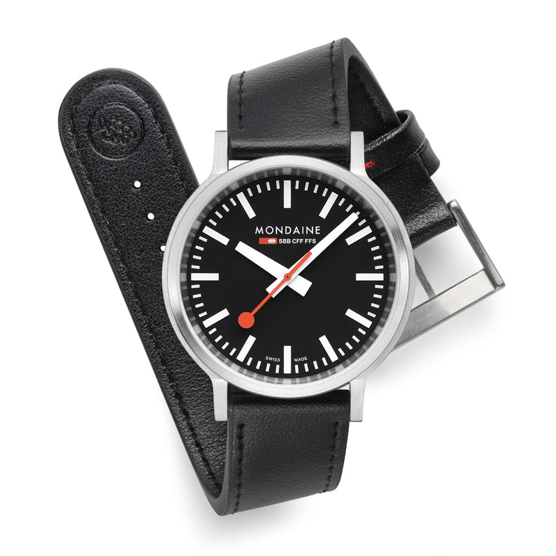 Mondaine wristwatch with a black leather strap and round face displaying a classic Swiss railway clock design.