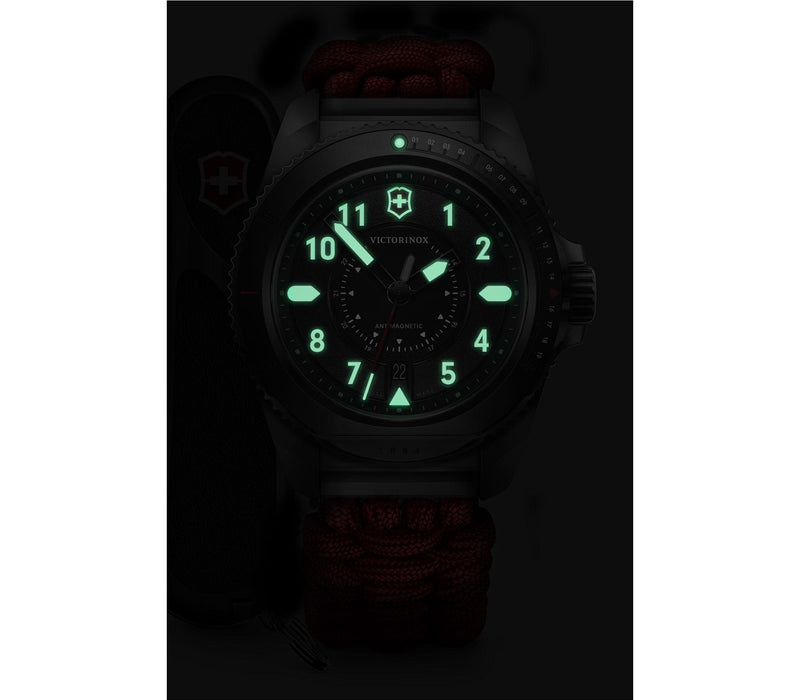 Luminous watch face with glowing green numbers and markings in darkness.