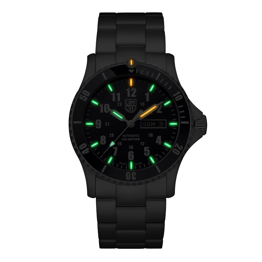Black wristwatch with luminous green and orange markers on the dial.