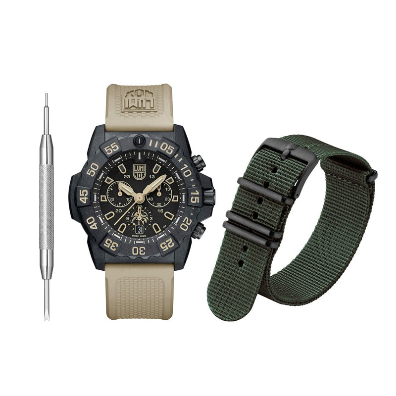 Rugged military-style wristwatch with a tan strap and black face, accompanied by a spare green fabric watch band and a tool.