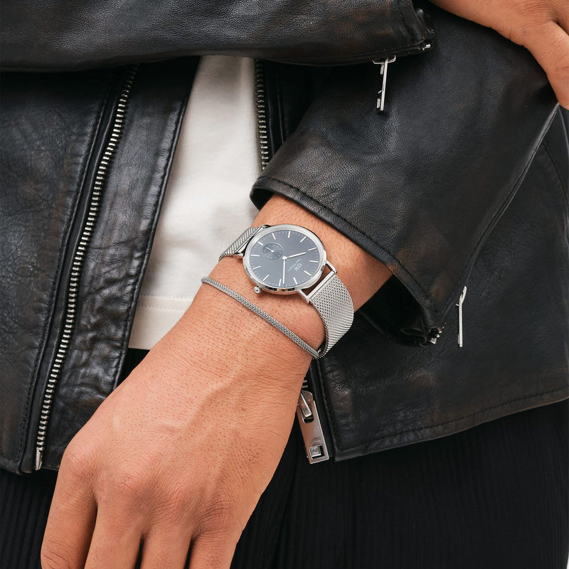 Sleek wristwatch with a round black face and silver mesh band.