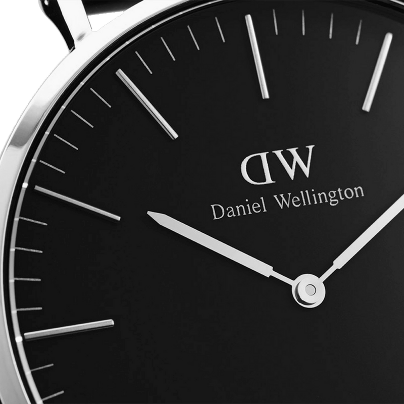 Sleek black-faced wristwatch with white hands and hour markers, displaying the Daniel Wellington brand.