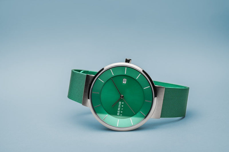 Green wristwatch with a mesh band and silver-toned case.