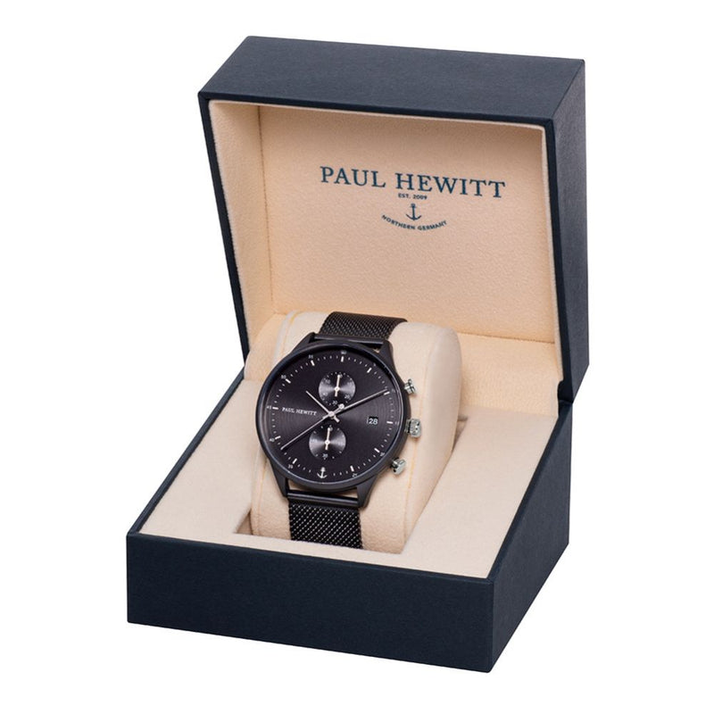 Black wristwatch with a mesh band displayed in an open presentation box.