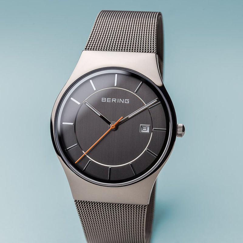 Sleek silver wristwatch with a gray dial and mesh metal band.