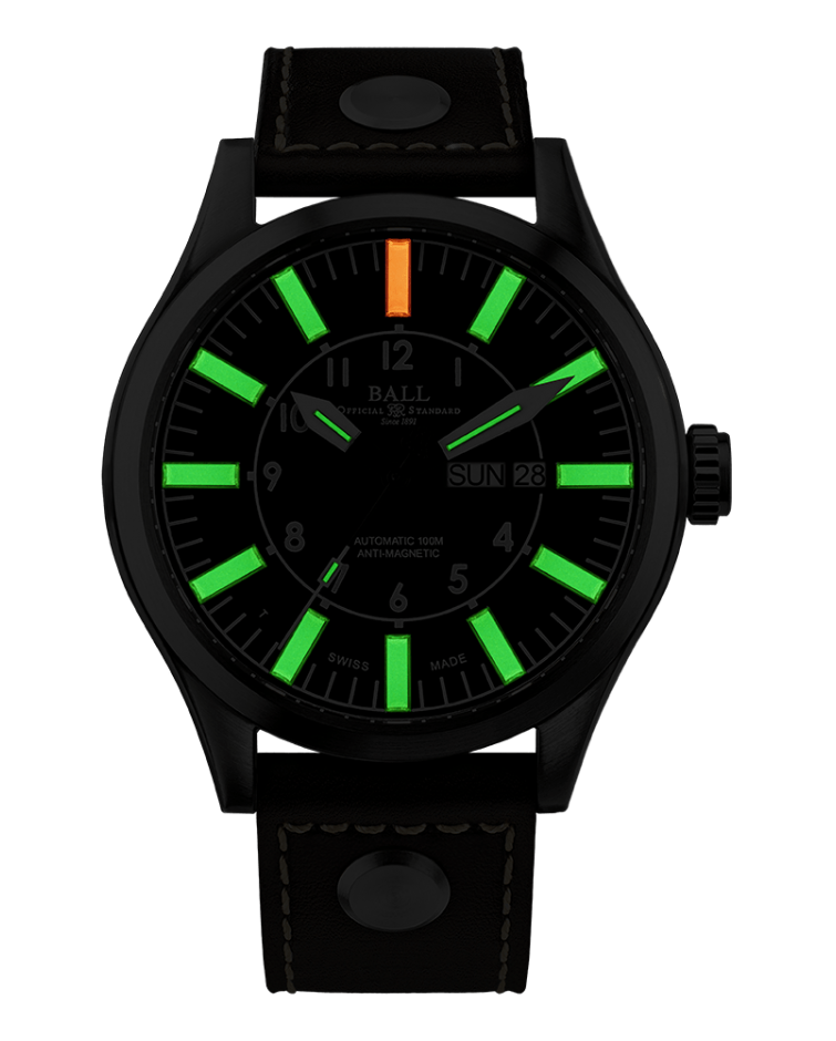 Black wristwatch with glowing green and orange hour markers on its dial.