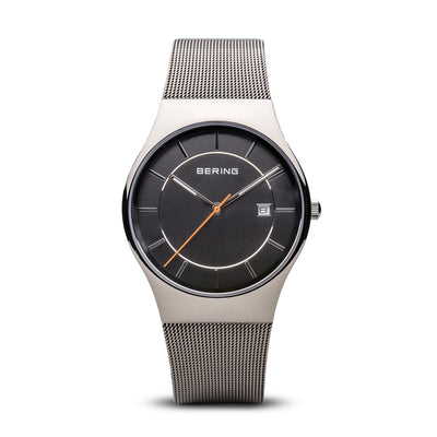 Sleek silver wristwatch with a black dial and mesh metal band.