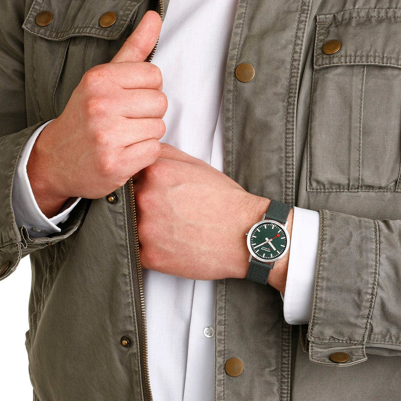 Wristwatch with a green face and white leather strap.