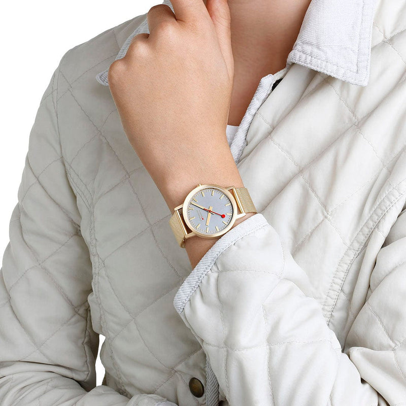 Gold wristwatch with a white face and minimalist design.