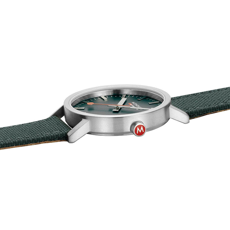 Wristwatch with a green dial and silver case attached to a green strap.