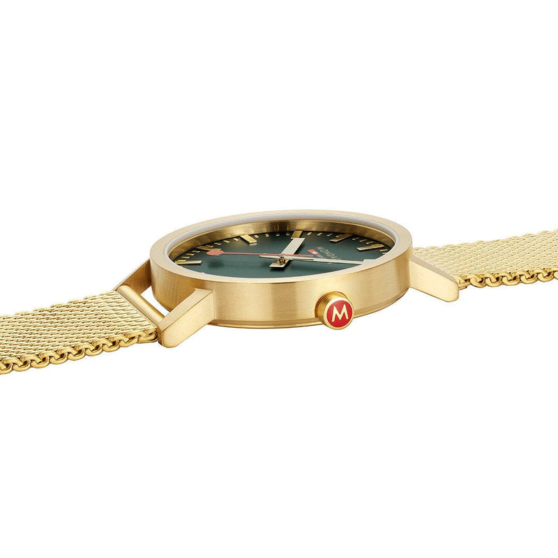 Gold wristwatch with a green dial and mesh band.