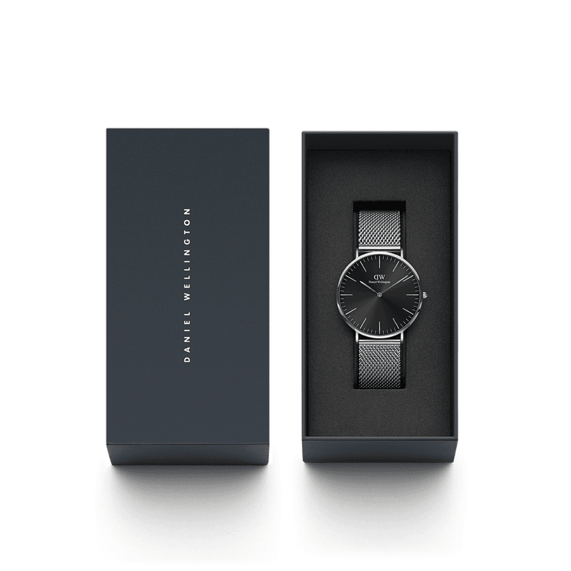 Sleek black wristwatch with a mesh metal band displayed in an open gift box.