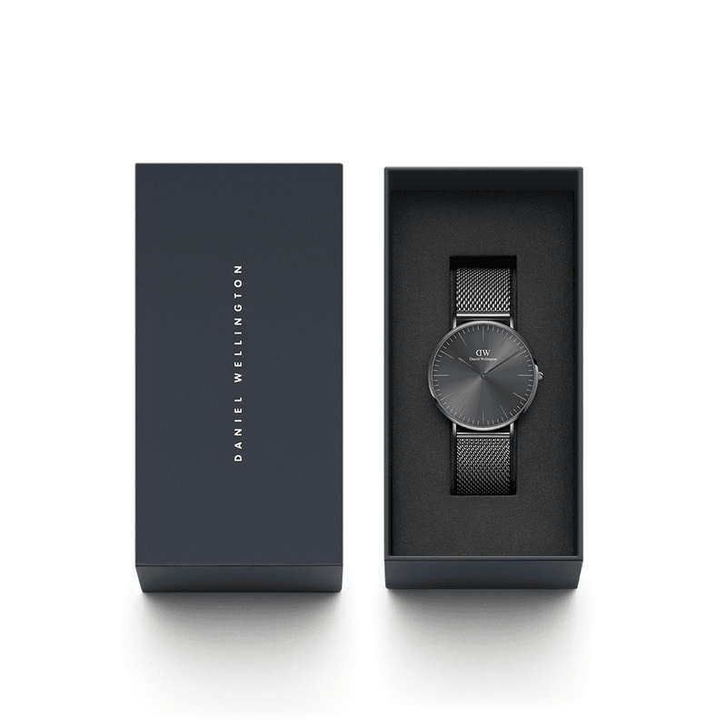 Sleek black wristwatch with a mesh metal band in an open gift box.