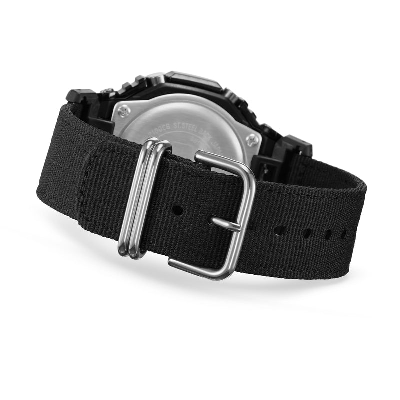 Black fabric watch strap with a metal buckle and partial view of a watch case.