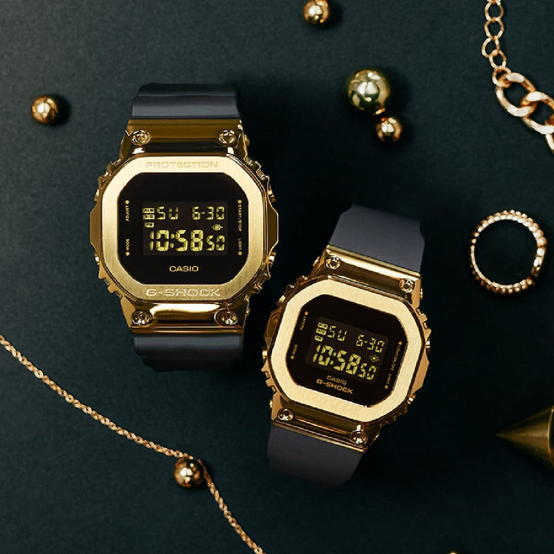 Two gold-toned digital watches with square faces and black bands.