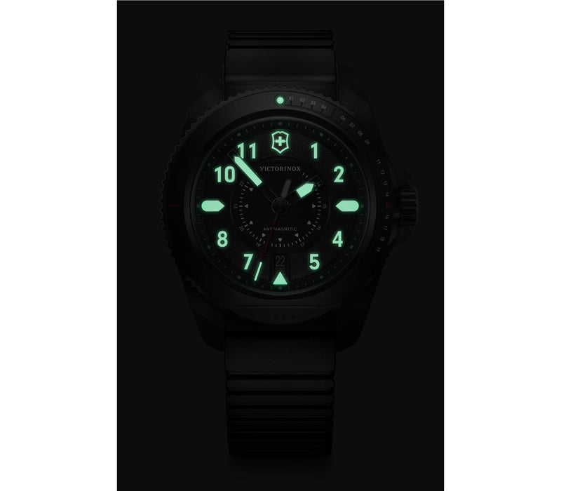 Glowing analog watch face with luminous green numbers and hands in the dark.