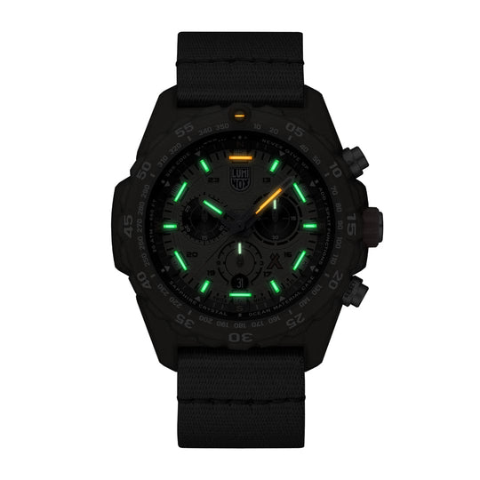 Black wristwatch with glowing green and yellow markers on the dial.