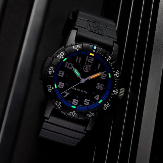 Sporty black wristwatch with colorful luminous markings on the dial and bezel.