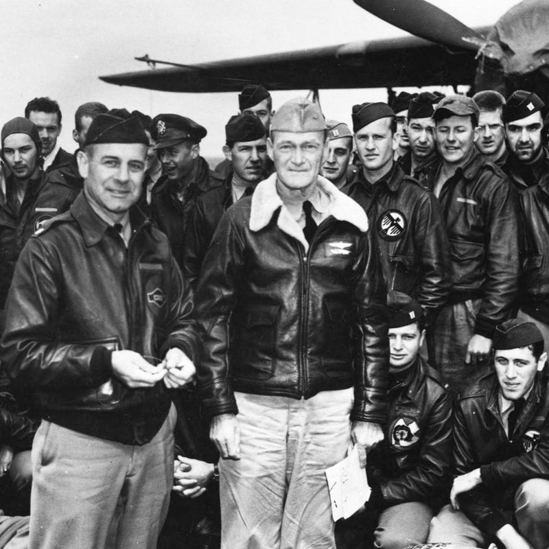 Group of World War II era military aviators posing together.