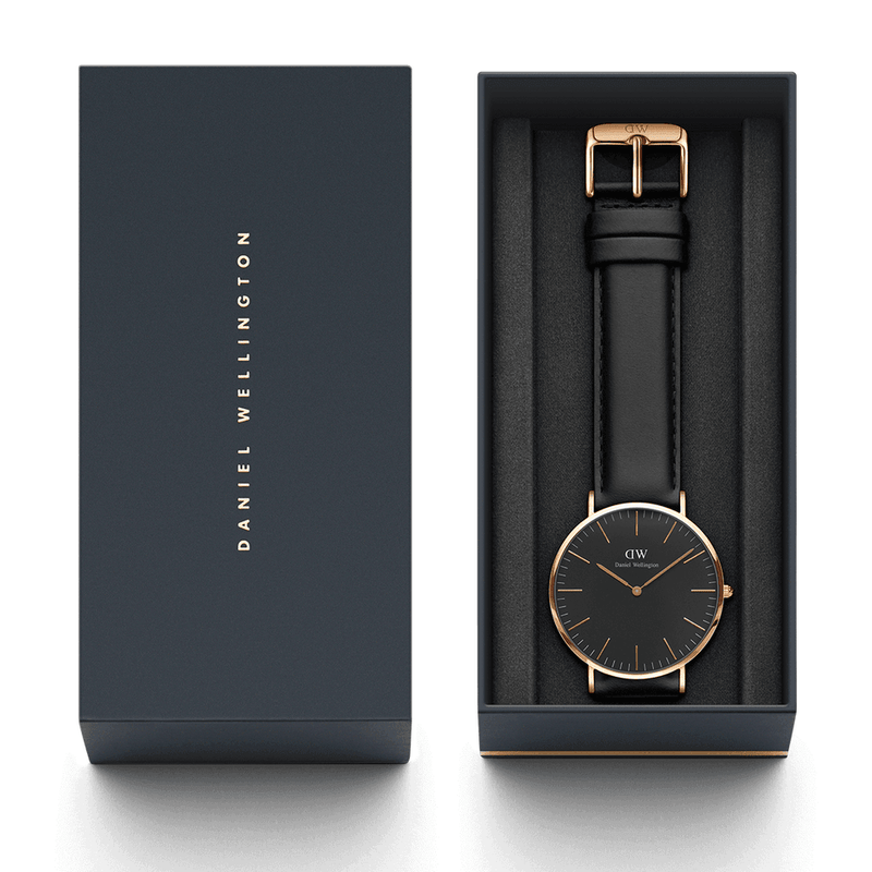 Elegant wristwatch with a black face and gold-tone case in a presentation box.