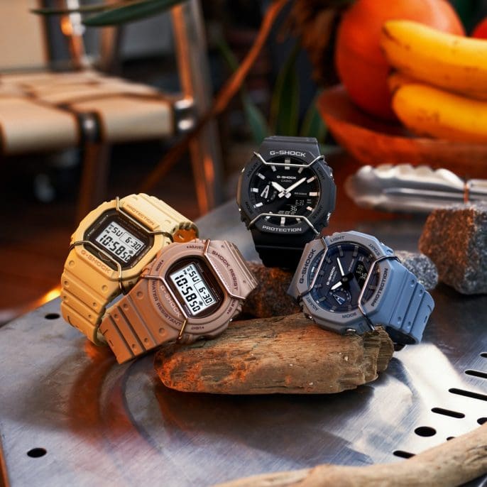 Collection of rugged digital wristwatches in various colors displayed on a rock.