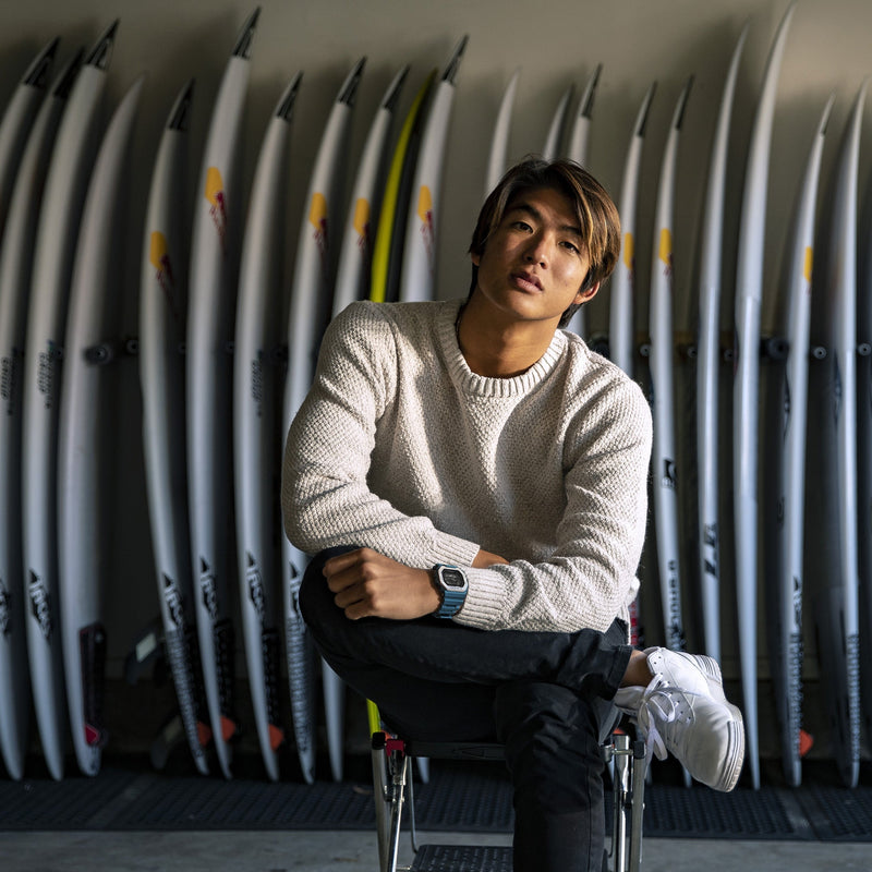 Young man in a white sweater sitting in a wheelchair.